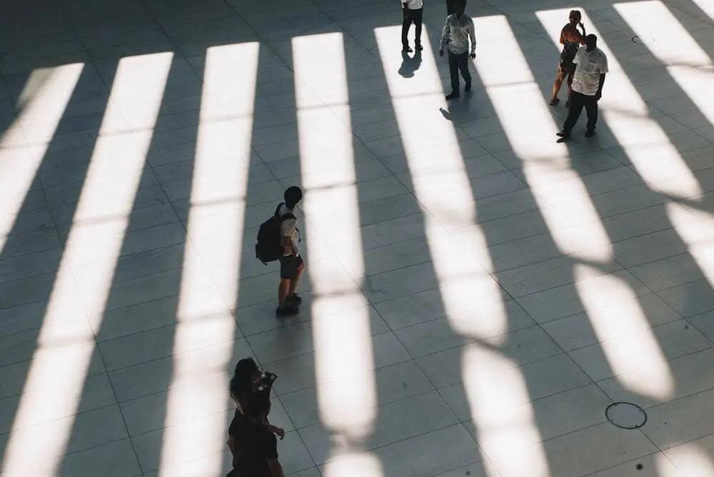 A group of people walking in a hallway with shadows.