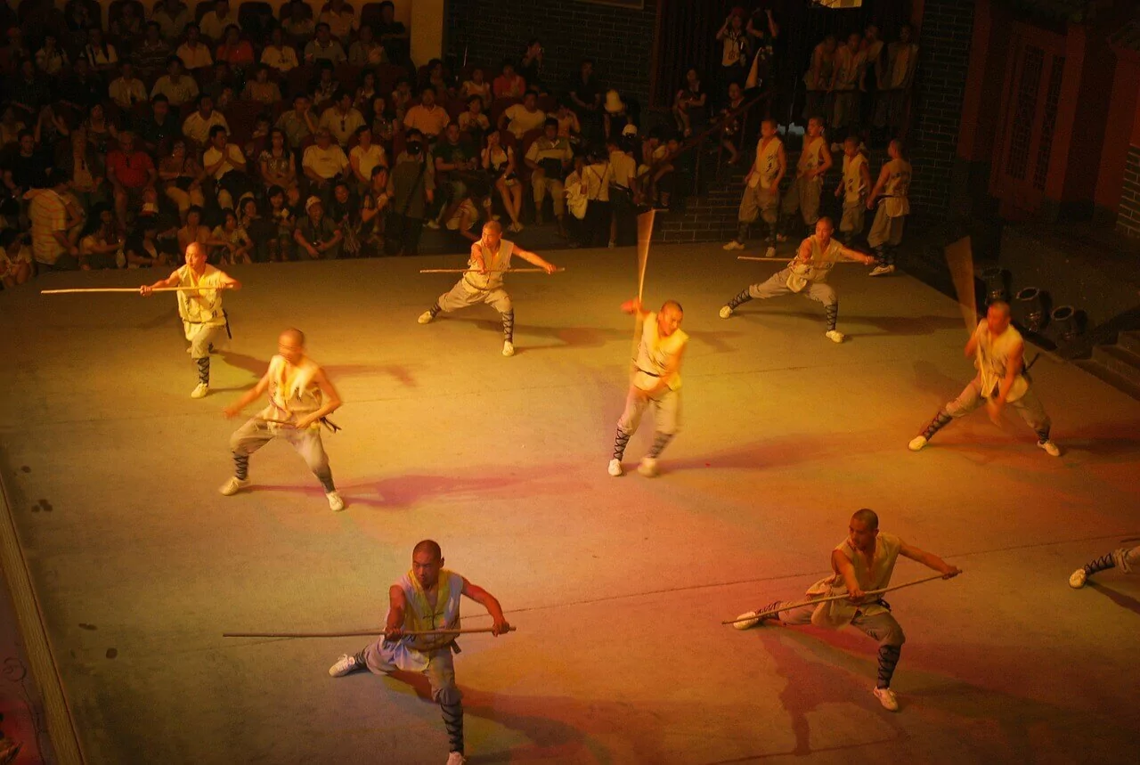 A group of people performing martial arts in front of an audience.