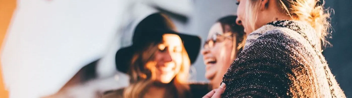 A blurry image of a group of women talking to each other.