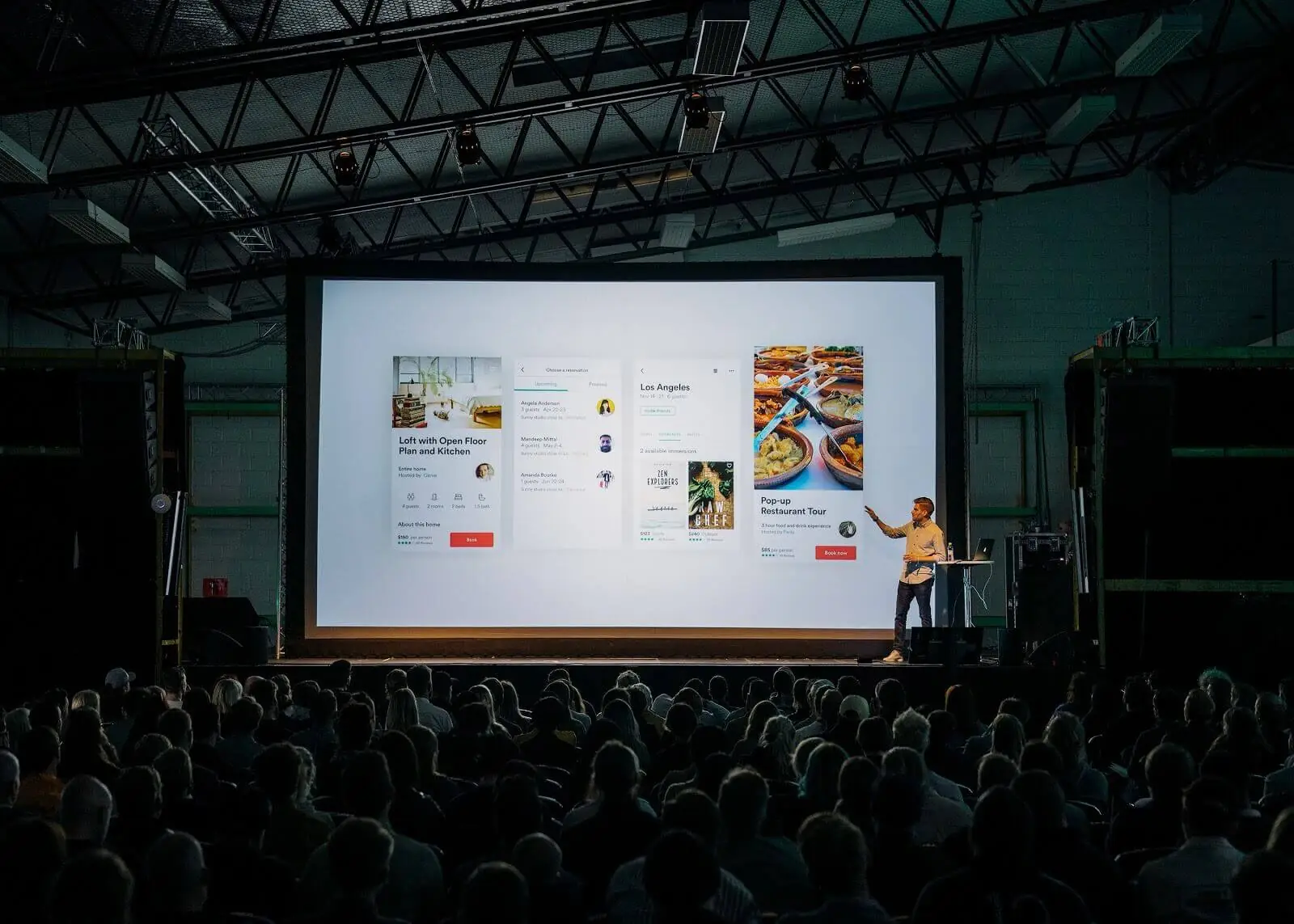 A group of people standing in front of a large screen.