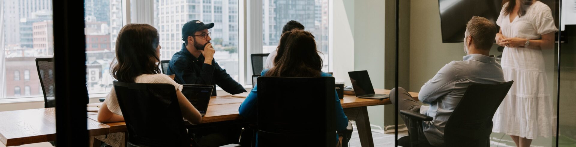 A group of people sitting at a table in a digital marketing agency office.