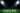 An american football field with spotlights and a ball.