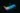 A rainbow colored macbook pro is sitting in the dark.